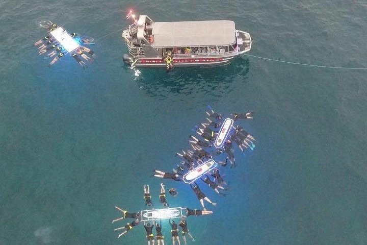 Outrigger canoes and a boat in turquoise water