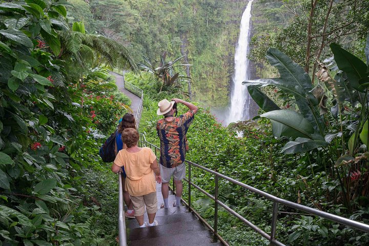 Visitors walking a trail toward a waterfall
