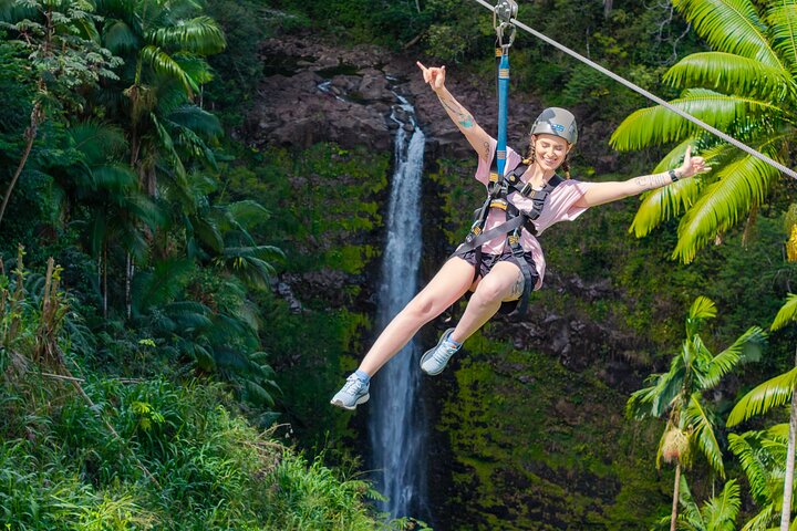 Rider on a zipline over a waterfall