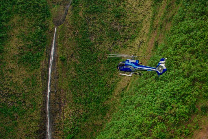 Helicopter above a steep green valley