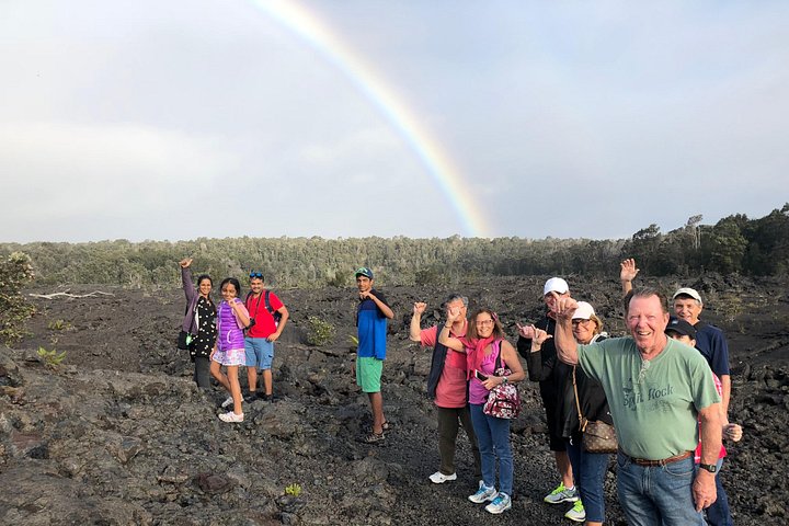 Group on lava rock under a rainbow