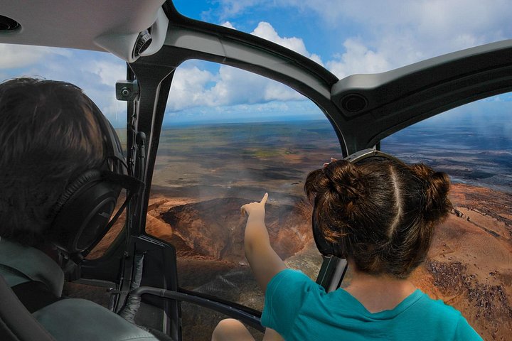 View from a helicopter cockpit toward a crater